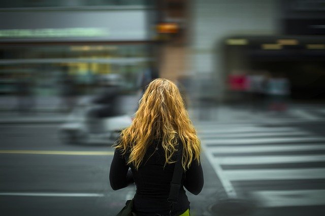 Mujer cruzando una calle en la ciudad
